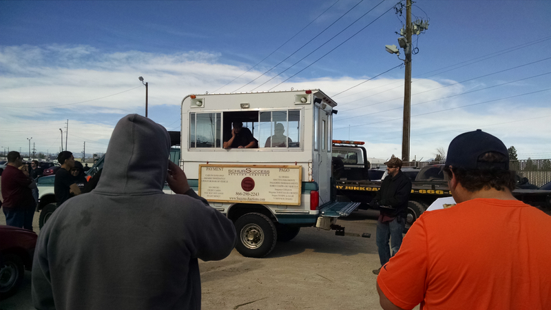 Two men shout garbled nonsense into microphones inside a tiny box in the back of an F-350 with a bullet hole in the passenger fender